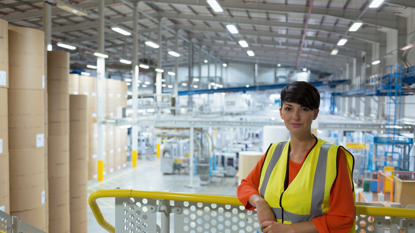 Mitarbeiter mit Warnweste in einer Papierfabrik